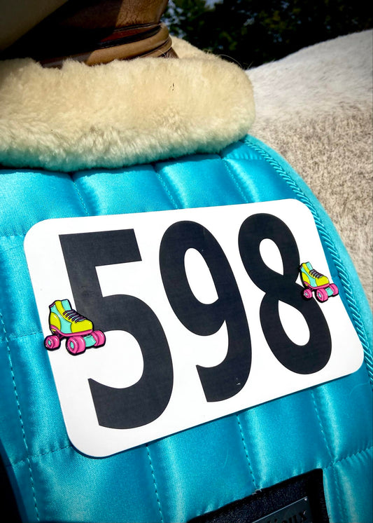 Roller Skate pins on a blue saddle pad.