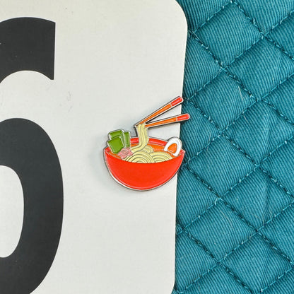 Teal quilted surface with a number 96 label and a small icon of noodles.