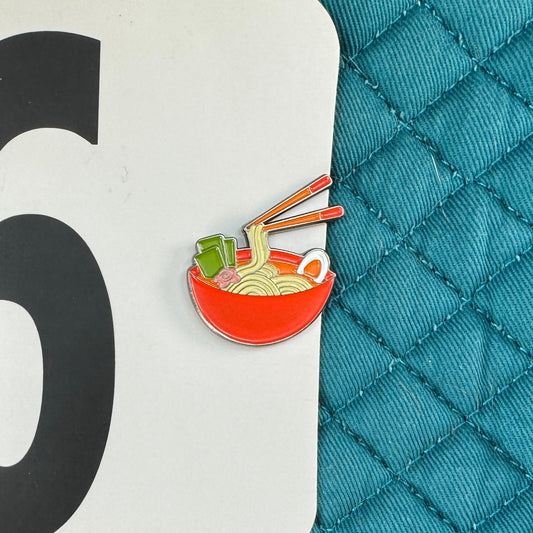 Teal quilted surface with a number 96 label and a small icon of noodles.